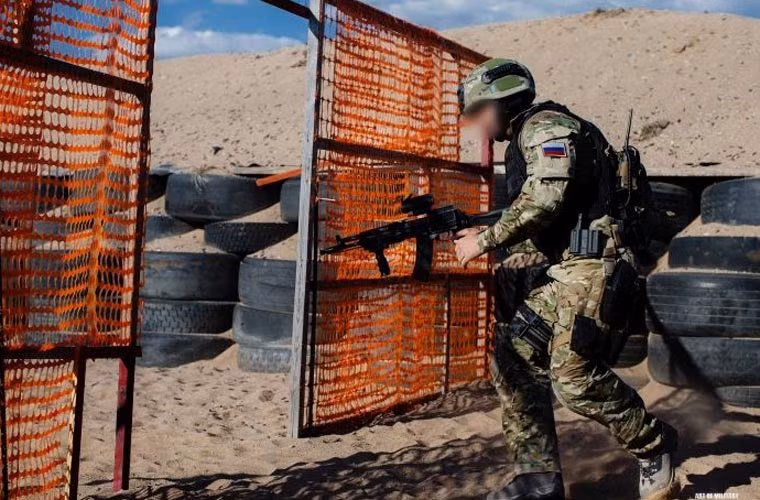 Một binh sĩ của đội Alpha vượt qua chướng ngại vật. Trong tay người lính này đang cầm biến thể đặc biệt của súng trường tiến công AKS-74M. Đây là biến thể nâng cấp từ AKS-74.