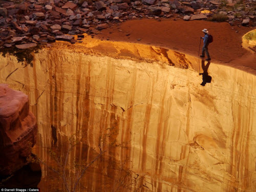 Người đàn ông này trông như đứng trên mép vực thẳm, nhưng thực chất là đang đi bộ dọc lòng sông ở Glen Canyon, bang Utah, Mỹ.