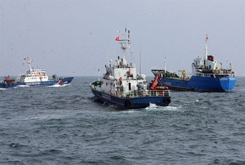 Các tàu cảnh sát biển truy đuổi, khống chế tàu buôn dầu trái phép (phải) đang cố tình chạy trốn.