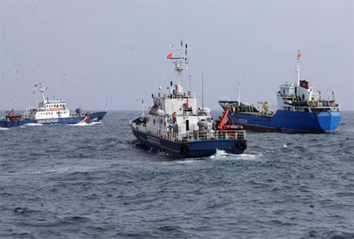 Các tàu cảnh sát biển truy đuổi, khống chế tàu buôn dầu trái phép (phải) đang cố tình chạy trốn.