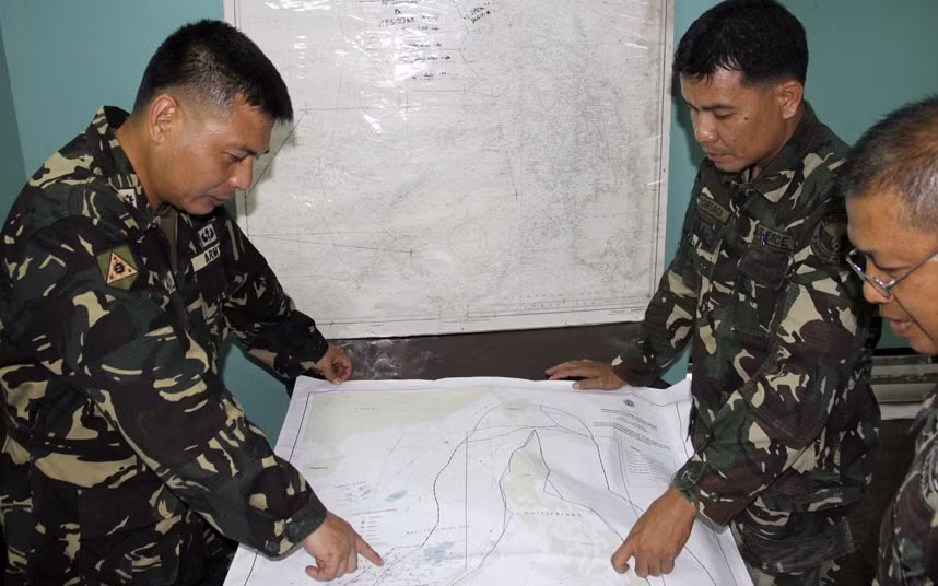 Các sĩ quan quân đội Philippines xem bản đồ khu vực tìm kiếm máy bay mất tích Malaysia.