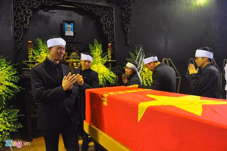 Trong tiếng nhạc réo rắt, từng người thân đội khăn trắng mặc đồng phục đen nối tiếp nhau tiến lại linh cữu nhìn anh Ngọc lần cuối.