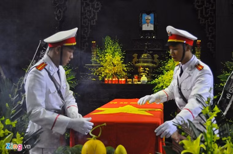 Sau tiếng kèn, đội nghi thức trang nghiêm tiến hành làm lễ phủ cờ đỏ sao vàng lên lĩnh cữu thượng úy Ngọc.