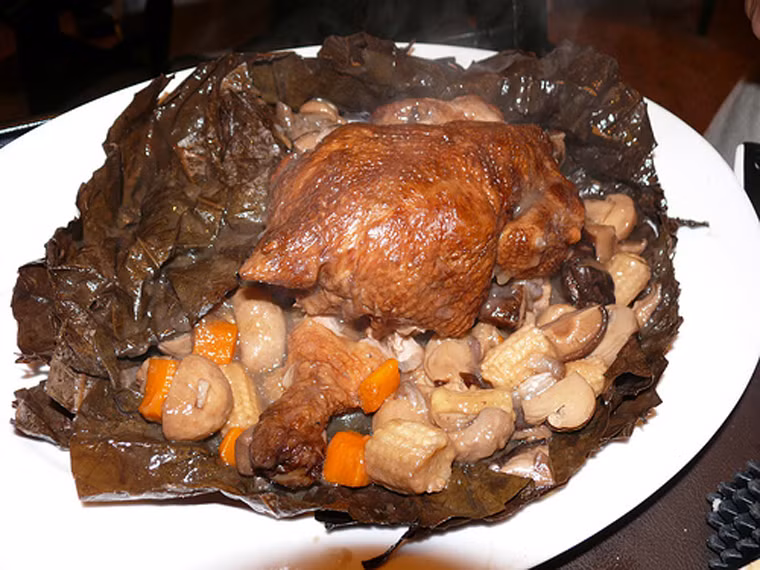 Món ăn có tên gọi như vậy khi một người ăn mày sống tại Hàng Châu tình cờ phát hiện ra cách chế biến độc lạ. Dù rất muốn làm chín gà để khỏa lấp cơn đói song anh chỉ có một con dao và đám lửa. “Cái khó ló cái khôn”, anh ta mổ rồi đắp bùn lên khắp mình chú gà rồi đem nướng. Khi chín, gà bốc khói nghi ngút, tỏa hương thơm vô cùng hấp dẫn.