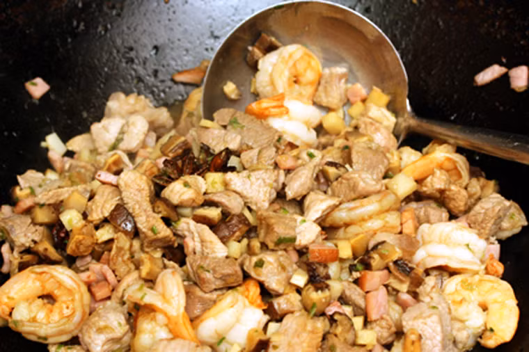 Thái nhỏ thịt lợn, tôm, nấm, măng xào trên ngọn lửa nhỏ chừng 3 phút. Khi thịt chín tái tiếp tục cho gừng băm nhỏ, hành lá và các nguyên liệu nhồi vào đảo đều.