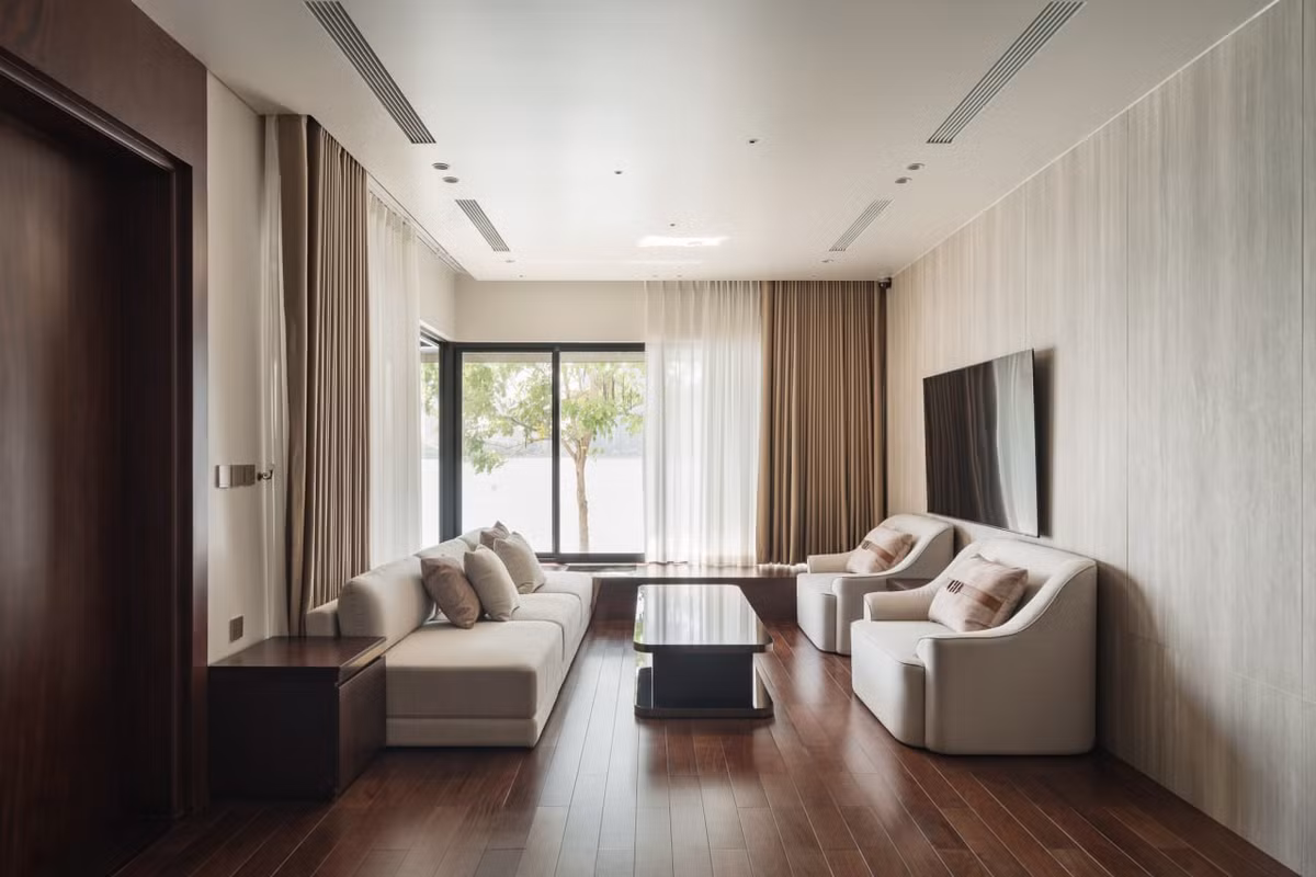 Nếu nhìn lướt qua tổng thể một căn nhà có mặt tiền rộng như thế này, ai cũng nghĩ rằng phòng khách sẽ rất to và hoành tráng, nhưng căn nhà này thì ngược lại. Không gian phòng khách với diện tích khiêm tốn và thiên về sự thư giãn, tận hưởng khoảng không gian trước nhà.