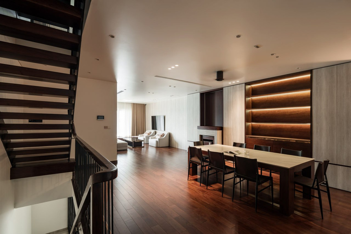 Phòng khách được thiết kế thu lại một diện tích khiêm tốn, để nhường chỗ cho khoảng không gian chung giao thoa với phòng ăn khá rộng rãi và thoáng. Không gian phòng khách được kê gọn gàng và một chiếc phản nằm được kê ngay cạnh cửa sổ kéo dài. Đây là không gian chủ nhà có thể nằm dài đọc sách, nghe nhạc và ngắm nhìn cảnh quan mặt nước.