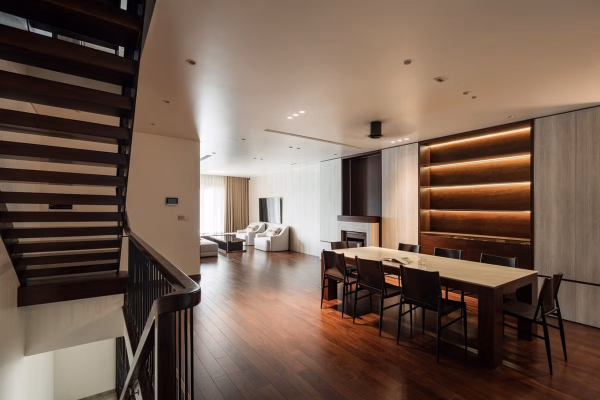 Phòng khách được thiết kế thu lại một diện tích khiêm tốn, để nhường chỗ cho khoảng không gian chung giao thoa với phòng ăn khá rộng rãi và thoáng. Không gian phòng khách được kê gọn gàng và một chiếc phản nằm được kê ngay cạnh cửa sổ kéo dài. Đây là không gian chủ nhà có thể nằm dài đọc sách, nghe nhạc và ngắm nhìn cảnh quan mặt nước.