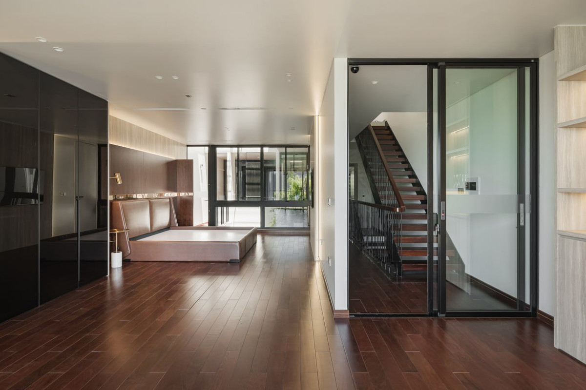 Bước lên cầu thang và đi qua hành lang kết nối trực tiếp đến không gian phòng ngủ tầng 4. Tầng 4 của căn nhà cũng là một không gian phòng ngủ, cấu trúc căn phòng này gần tương tự tầng 3 nhưng cách bài trí có phần phá cách và trẻ trung hơn. Điều thú vị của cấu trúc thang bộ chạy dọc nhà, đó là sự kết nối chuyển tiếp giữa hành lang – cầu thang – phòng ngủ chứ không bị chia cắt như một số cầu thang chữ U truyền thống.