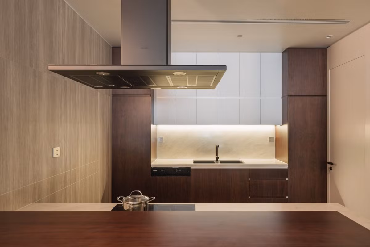 Tầng 2 của căn nhà được thiết kế như một căn hộ với không gian phòng khách, ăn và bếp liên thông. Tại đây, bàn ăn của căn nhà thiết kế rộng và dài với chất liệu đá thạch anh và gỗ óc chó cao cấp. Hệ tủ tường đóng vai trò liên kết về hình khối và tạo sự kết nối từ không gian khách đến phòng ăn và kéo dài đến khu bếp. Không gian bếp gọn gàng, tinh tế.