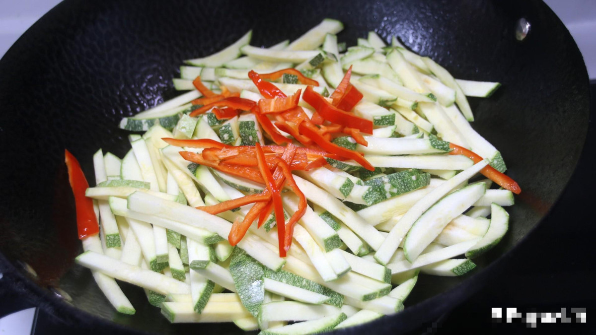 Để lại chút dầu trong nồi, sau đó đổ bí đỏ và ớt đỏ vào xào trên lửa lớn, đảo nhanh. Xào chín 70% thì bắt đầu đổ thịt đã xào trước đó vào. Nêm gia vị: muối, tinh chất gà, đường vào và đảo đều. Cuối cùng cho hành lá vào, đảo thêm 2 lần rồi bắc ra thưởng thức.