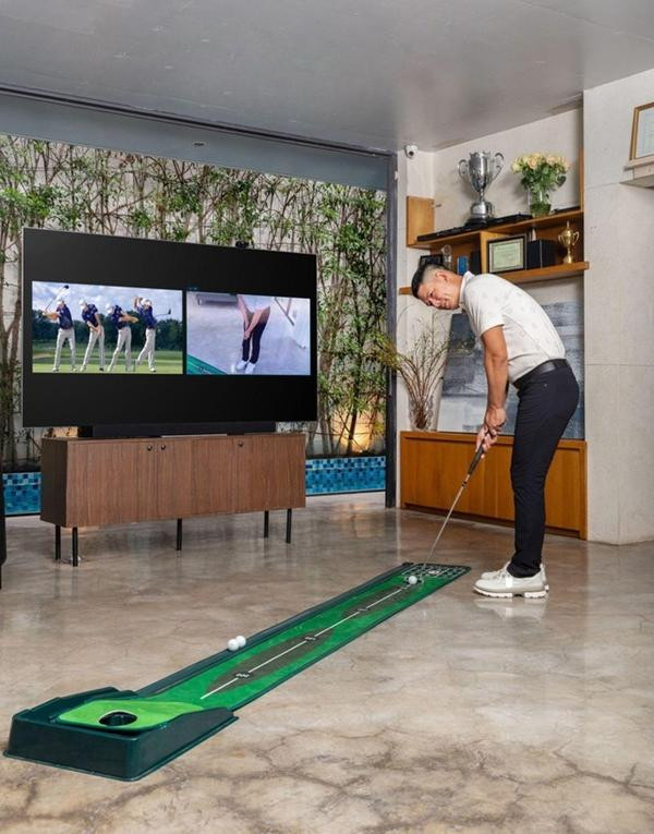 ình Minh chơi golf trong phòng khách tiện nghi. Với tiêu chí nhà là nơi để quây quần và gắn kết, nên vợ chồng Bình Minh - Anh Thơ đã thiết kế một không gian mở thoáng đãng ở ngay tầng một của căn biệt thự.