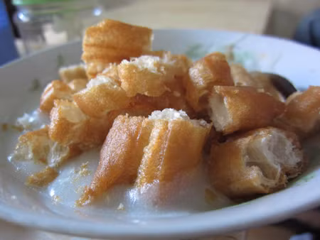 Cháo trai cũng là một lựa chọn lý tưởng. Cháo tấm được nấu chín kĩ ăn cùng thịt trai quẩy và rau thơm.