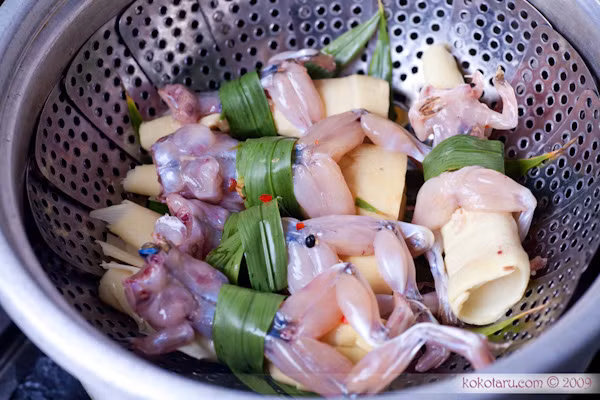 Ngày nay thịt nhái và ếch được được lột sạch da nhưng trước đây người dân tộc Mường Hòa Bình sau khi bắt nhái về chỉ đem sóc giỏ nhái qua nước cho bớt nhớt sau đó đổ cả giỏ vào nồi canh măng đang sôi sùng sục. Con nhái sống gặp nóng sẽ vội vàng quắp lấy miếng măng trong nồi thành món nhái ôm măng.