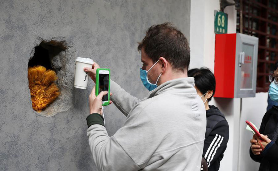 Khác với không gian sang trọng hay bàn ghế đầy đủ, quán cà phê chỉ có duy nhất một cái lỗ thủng. Khách hàng phải xếp hàng, quét mã QR để gọi cà phê. Một vài phút sau, một bàn tay lạ như gấu bông, mèo,... sẽ đưa cốc cà phê cho khách.