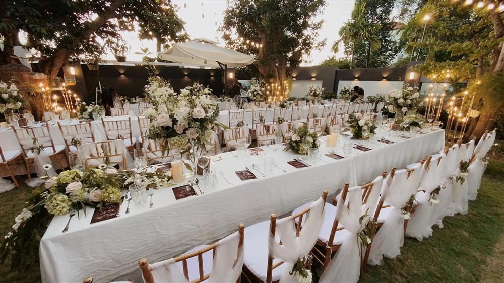 hông gian tiệc kỷ niệm đã được hoàn tất trang trí từ sớm. Thoạt nhìn nơi đây chẳng khác nào một đám cưới sang trọng. Bàn tiệc gần như phủ kín khuôn viên sân vườn, từng bó hoa tươi được bài trí tinh tế, đẹp mắt.