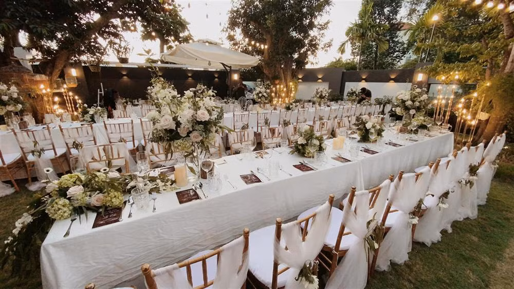 Không gian tiệc kỷ niệm đã được hoàn tất trang trí từ sớm. Thoạt nhìn nơi đây chẳng khác nào một đám cưới sang trọng. Bàn tiệc gần như phủ kín khuôn viên sân vườn, từng bó hoa tươi được bài trí tinh tế, đẹp mắt.