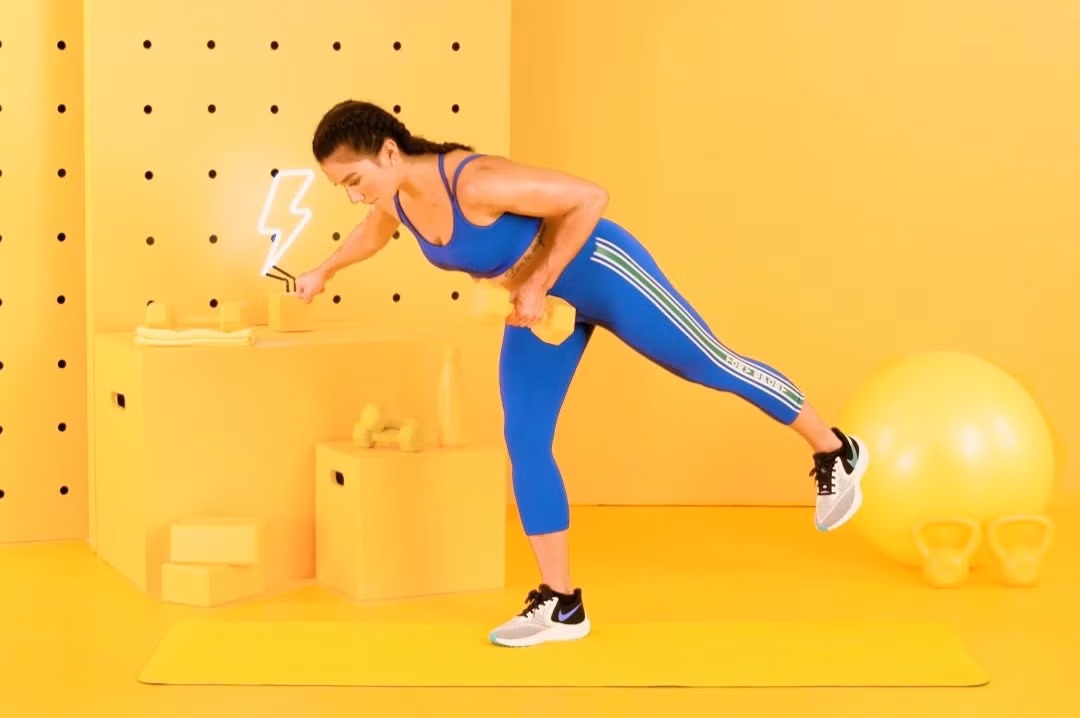  Nâng tạ thăng bằng với một chân: Bạn cầm một quả tạ trong tay trái, lòng bàn tay hướng vào trong. Sau đó, chân phải làm trụ, chân trái từ từ nâng lên sao cho song song với sàn và đẩy ra sau, người duỗi về phía trước. Tay trái cầm tạ từ từ nâng lên, ép sát ngực, giữ trong 5 giây. Động tác này đòi hỏi sự thăng bằng, chỉ tay nâng tạ chuyển động còn các phần còn lại của cơ thể giữ nguyên. Sau đó, hạ tay trái và thực hiện 3-4 hiệp, mỗi hiệp 12 lần rồi đổi bên. Ảnh: Womenshealthmag.