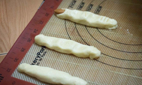 Bước 5: Lấy bột ra, chia bột thành từng khối nhỏ và nặn hình ngón tay. Dùng hạt hạnh nhân gắn ở đầu sao cho giống móng tay.