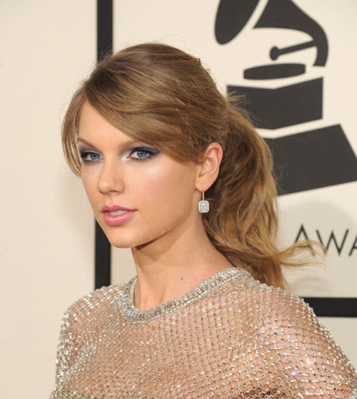 Taylor Swift chọn phong cách trang điểm kẻ mắt mèo yêu thích đi kèm kỹ thuật mắt khói với gam xanh cobalt nhạt và tô son hồng đào ngọt ngào.