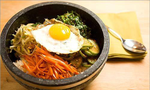 Cơm trộn Bibimbap. Để làm món cơm trộn này, trước hết phải phải làm chín thịt bò (hoặc thịt lợn), cà rốt, giá đỗ, rau cải, trứng ốp la. Cho cơm vào chảo hoặc bát, xếp xen kẽ các nguyên liệu đã làm chín vào, quả trứng sẽ xếp lên trên cùng. Rắc đều vừng và dầu vừng lên là được