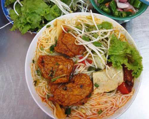 Bún cá Đà Nẵng. Bún cá Đà Nẵng ngun ngút mắt với màu vàng của chả chiên, trắng của chả hấp, có miếng xắt nhỏ, có miếng viên được tô điểm bởi hành xanh, cà chua đỏ và những loại rau ăn kèm tươi non, mỡ màng. Mùi thơm rất riêng của bún Đà Nẵng trộn với vị ngọt lành của nước lèo kết hợp cùng cái cay nóng, chua dịu của hành ớt ngâm quyến rũ khó tả.