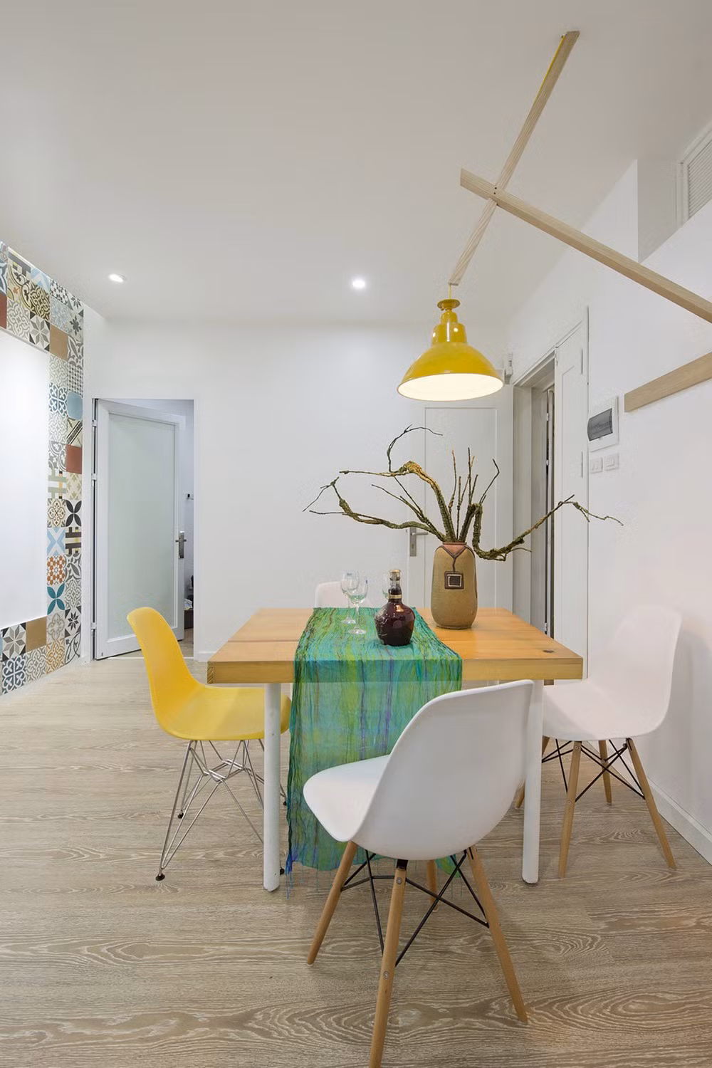 Những món đồ nội thất màu vàng, xanh lá cây và màu da cam làm không gian của căn phòng trở nên ấm cúng hơn, đồng thời tạo nên sự tương phản mạnh mẽ với các bức tường trắng tinh khôi.