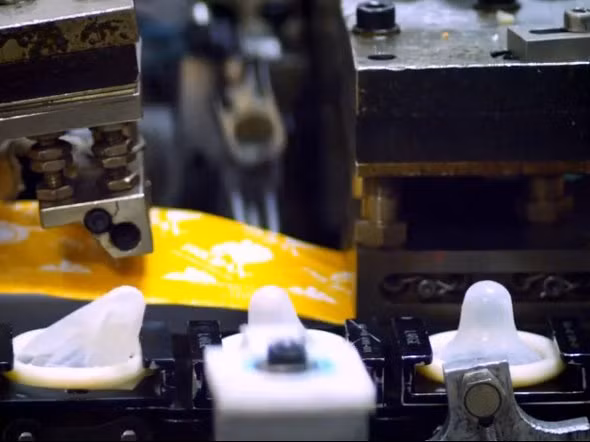 Ở gần cuối quy trình, bao cao su được tiêm thêm chất bôi trơn và tạo màu, tạo mùi tùy loại.