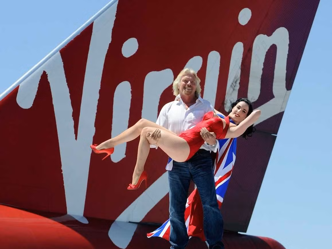 Tỷ phú Branson không bao giờ từ chối cơ hội chụp ảnh với một cô người mẫu. Đây là tấm ảnh ông chụp cùng một cô người mẫu trên đỉnh đuôi của một chiếc máy bay thuộc hãng hành không Virgin Atlantic của ông.