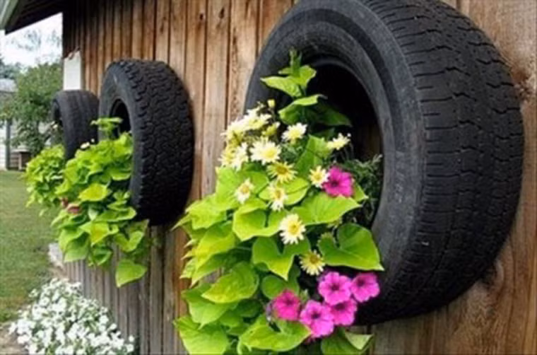 Bạn cũng thể biến những chiếc lốp xe cũ thành vườn hoa treo độc đáo như thế này. Đầu tiên, bạn hãy cắt lốp xe làm đôi và móc thêm dây xích để tạo thành chiếc giỏ trồng hoa xinh xắn. Sau đó, bạn chỉ cần đổ đất vào bên trong và trồng những loài hoa yêu thích. Như vậy, bạn đã có thêm một những vườn hoa treo bắt mắt cho nhà đẹp.