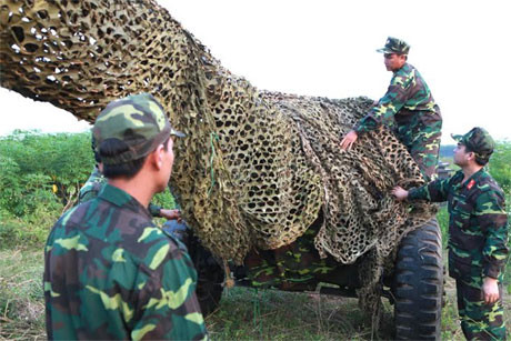 Hàng trăm quân nhân dự bị được Lữ đoàn 675 tiếp nhận từ 3 huyện Sóc Sơn, Gia Lâm, Đông Anh thuộc TP Hà Nội bảo đảm đúng, đủ về số lượng và chất lượng. Ngay sau khi tiếp nhận, các quân nhân được cấp phát quân trang, vũ khí trang bị theo quy định và biên chế vào các đơn vị. Các quân nhân dự bị động viên lần này sẽ tiếp tục được huấn luyện bổ sung sẵn sàng tham gia chiến đấu. Ảnh: Ngụy trang pháo tại vị trí tập kết.
