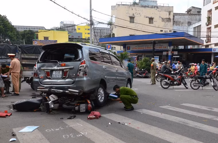 Chiếc xe do thợ rửa xe điều khiển cuốn 2 xe máy và các nạn nhân vào gầm.