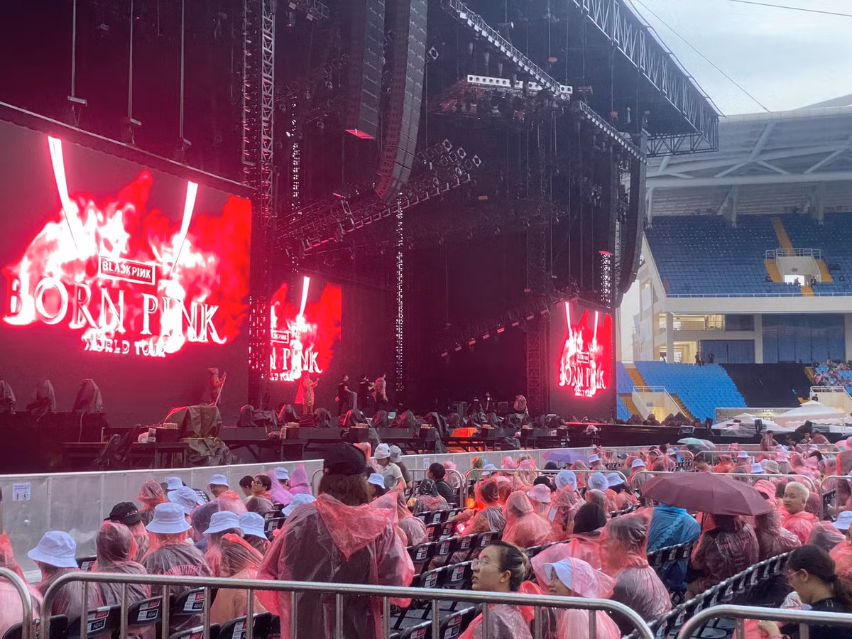 Trước đó, người hâm mộ phải mặc áo mưa vào sân khấu tìm chỗ ngồi do cơn mưa bất chợt lúc 17h20.