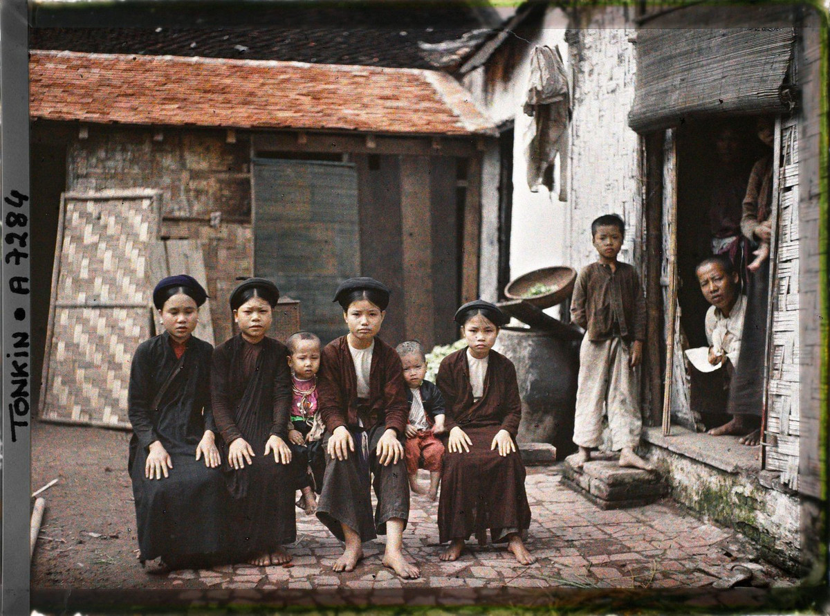 Các thiếu nữ và trẻ em con một gia đình khá giả ngồi trên chiếc ghế dài ở sân nhà, Hà Nội năm 1915. Ảnh: Léon Busy/Collections.albert-kahn.hauts-de-seine.fr.