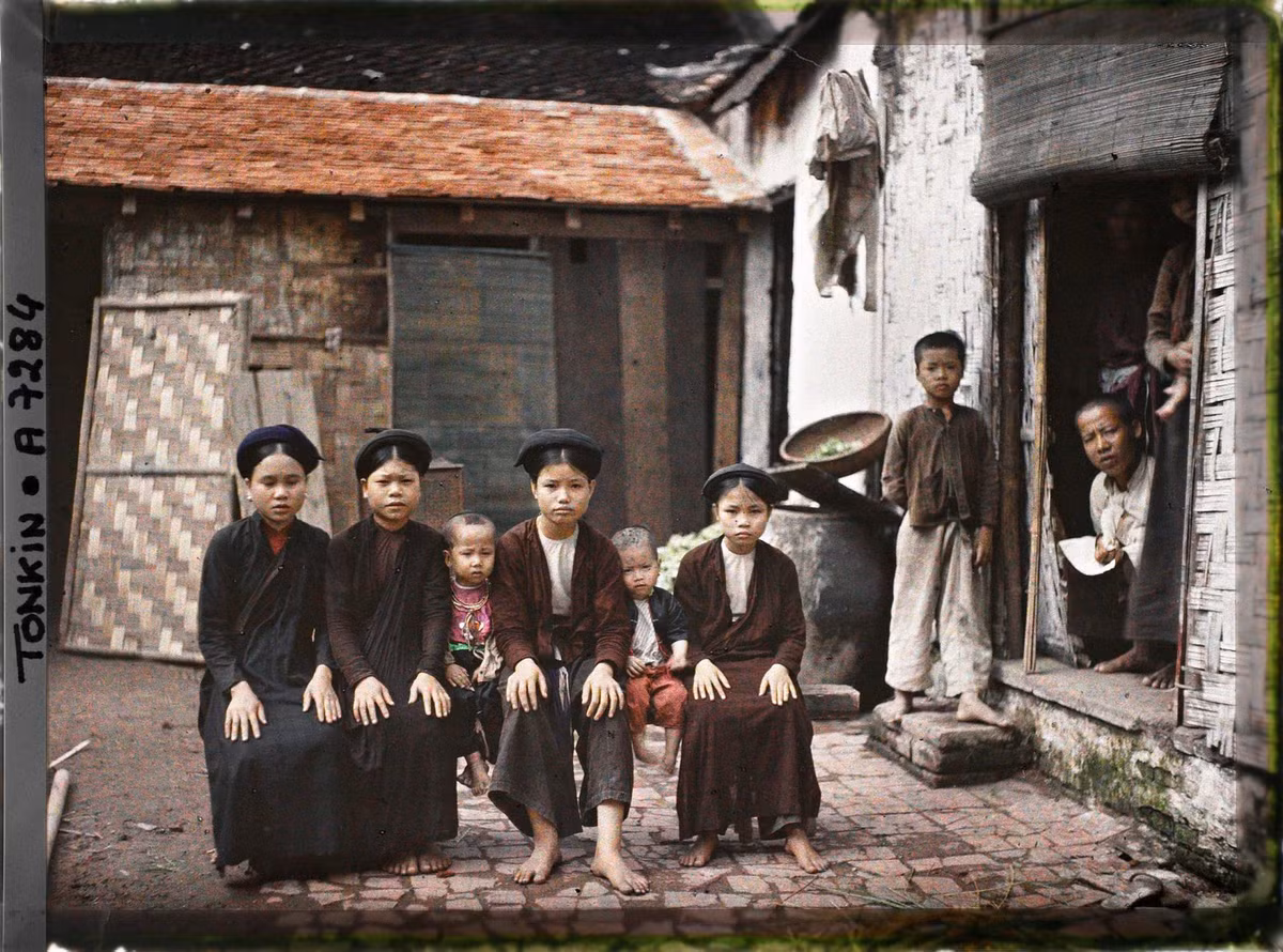 Các thiếu nữ và trẻ em con một gia đình khá giả ngồi trên chiếc ghế dài ở sân nhà, Hà Nội năm 1915. Ảnh: Léon Busy/Collections.albert-kahn.hauts-de-seine.fr.