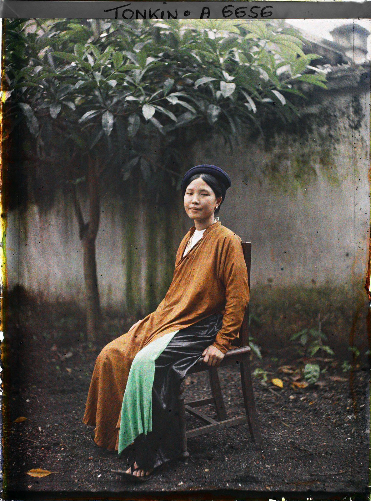 Tiểu thư Hà Nội ngồi trên ghế gỗ.