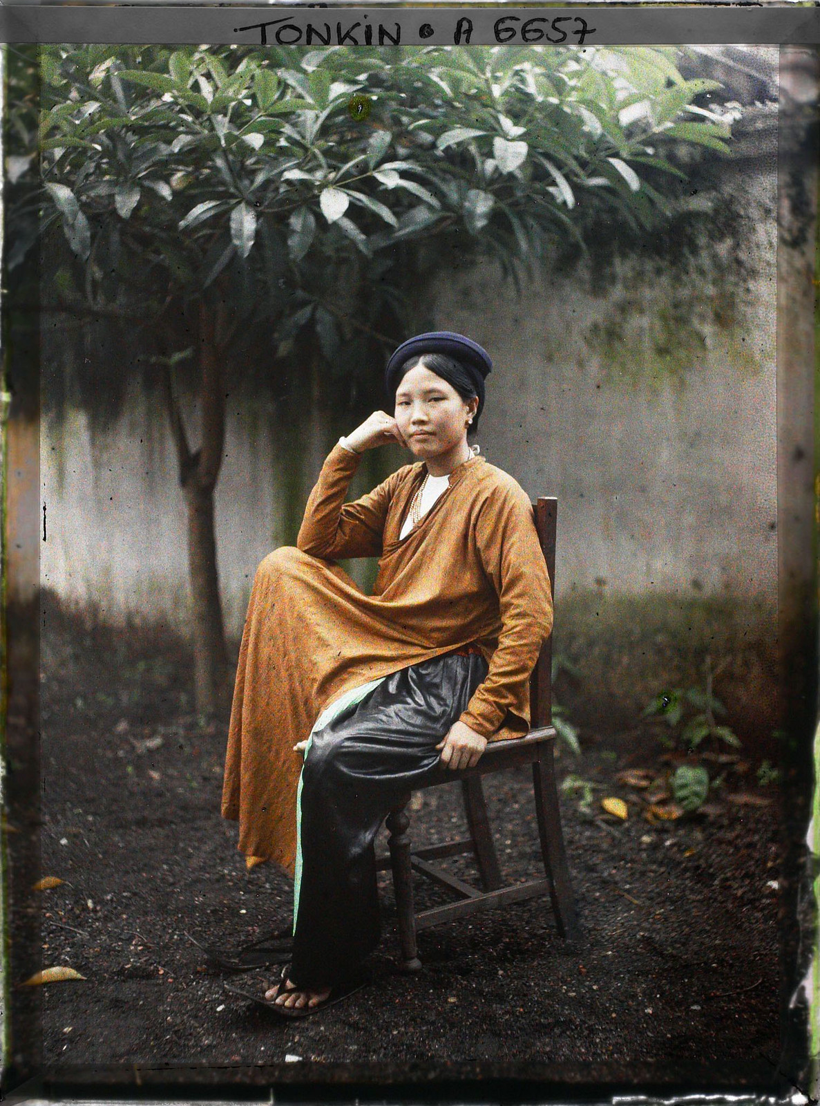 Tiểu thư Hà Nội ngồi trên ghế gỗ.