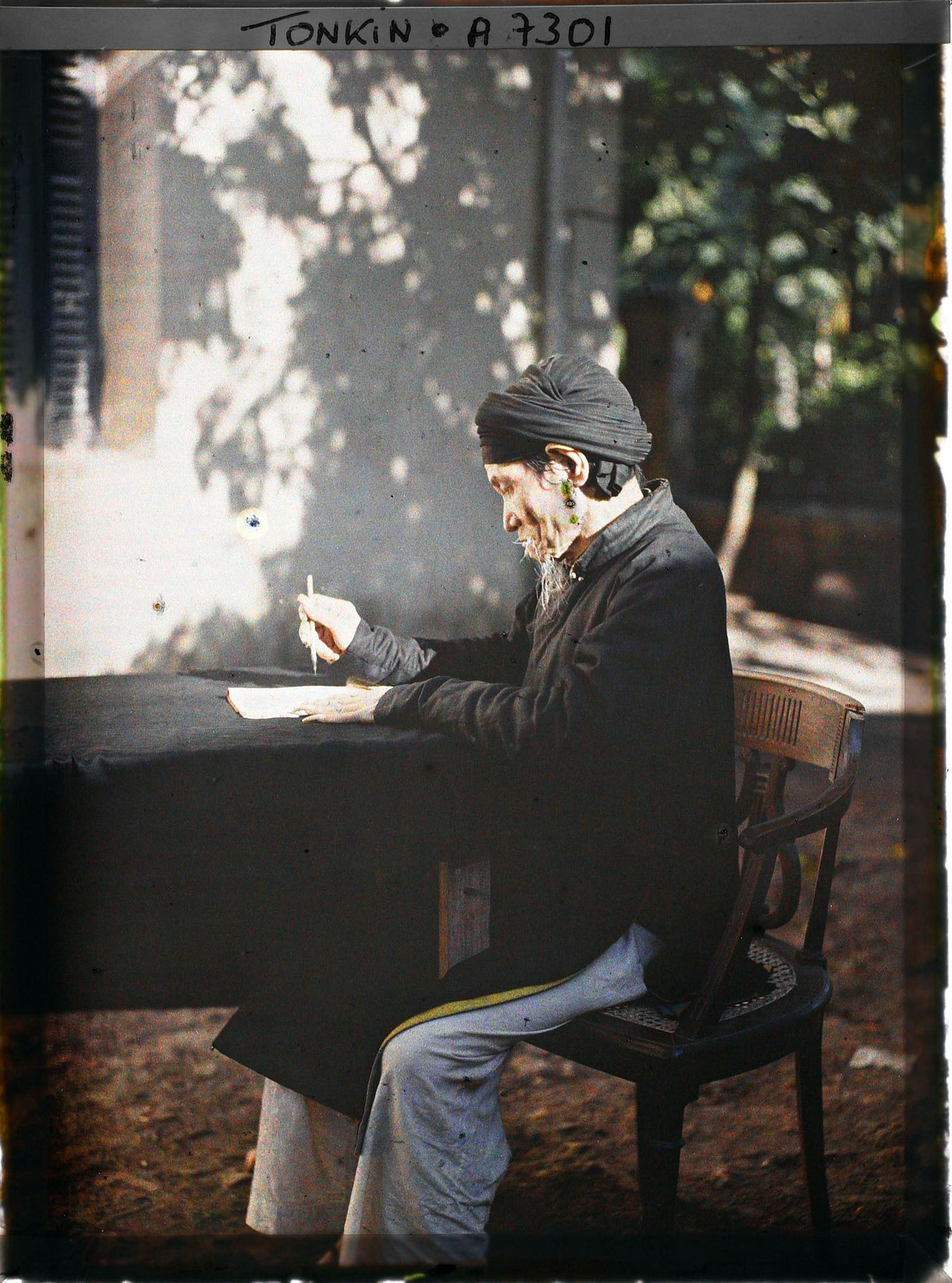 Vị học giả cầm bút lông viết văn.