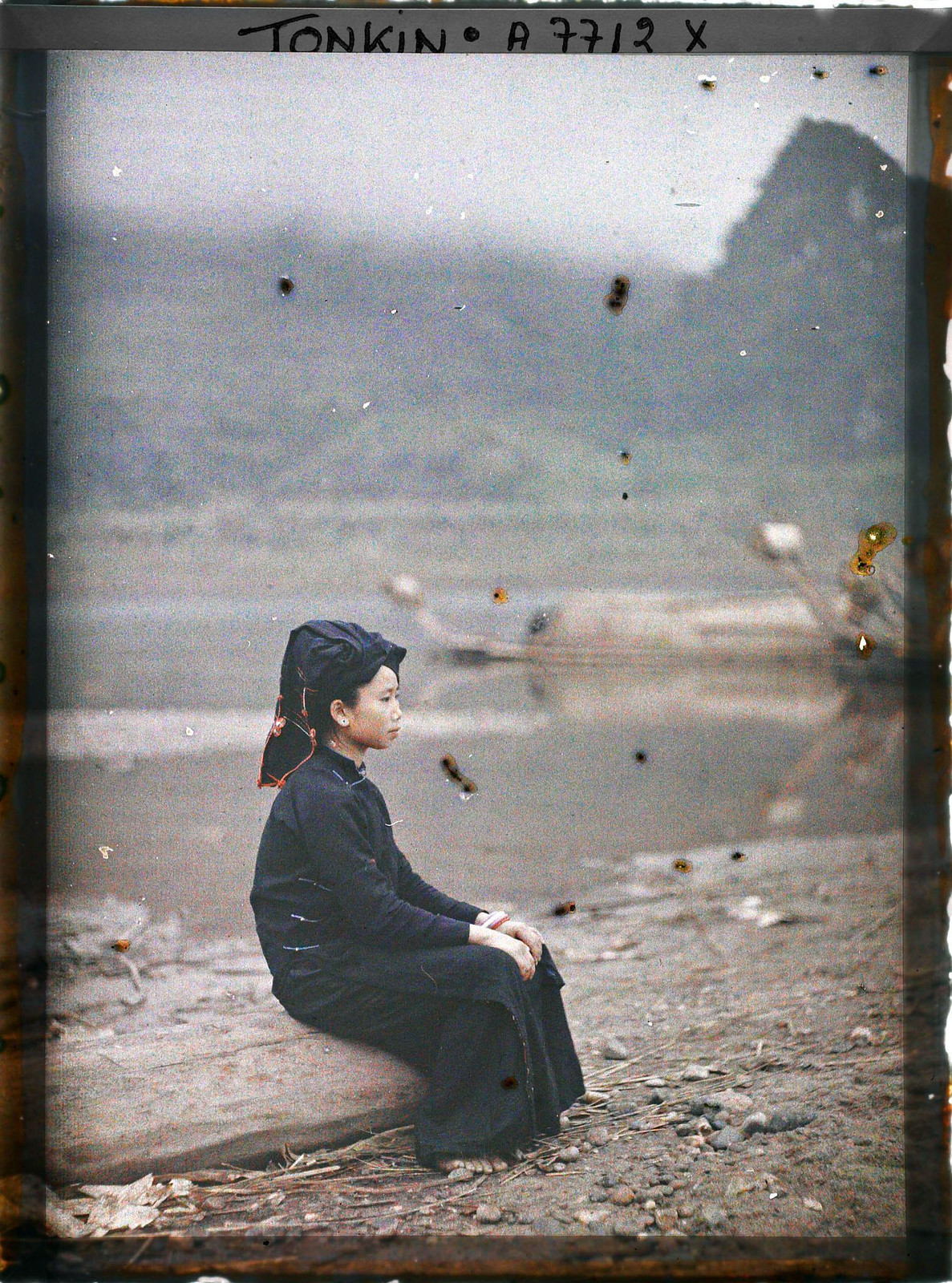 Sơn nữ ngồi trên khúc gỗ.