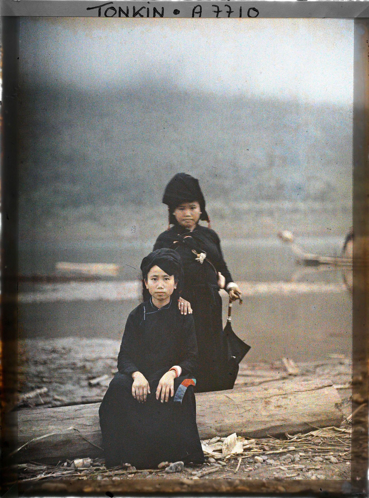 Hai phụ nữ dân tộc thiểu số đứng ở bờ sông.