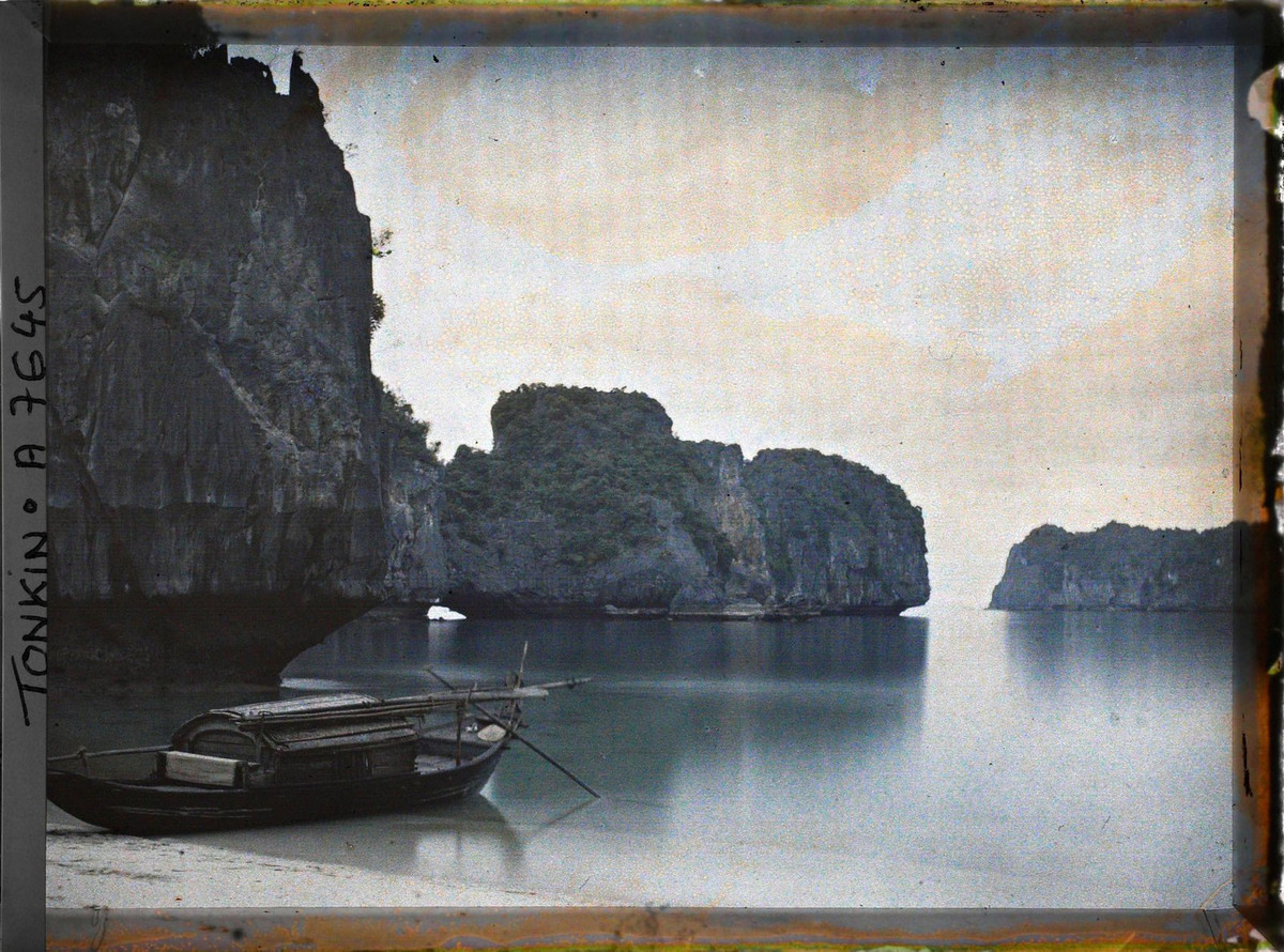 Con thuyền thô sơ nằm trên bờ cát.