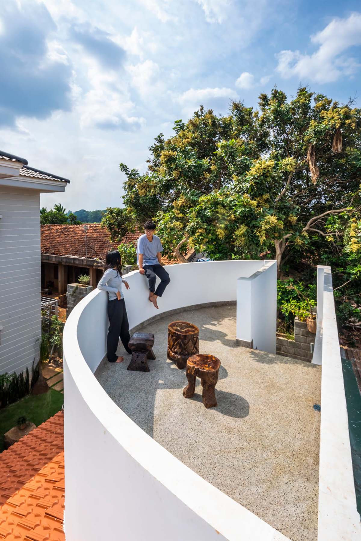 Trên mái có 1 sân thượng cong hình con thuyền, tạo sự mềm mại, tương phản với mái hiên trải dài của công trình. Gia chủ muốn thiết kế sân thượng dùng để ủ và phơi nắng hũ đậu, tuy nhiên khi hoàn thành, nơi đây trở thành địa điểm đa năng, có thể dùng cho việc thư giãn của mọi thành viên trong gia đình.