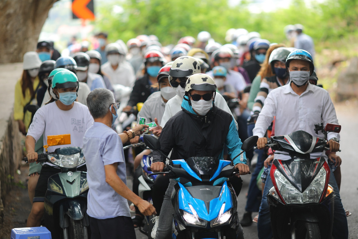 Hàng trăm người đi xe máy phải nối đuôi nhau chờ đến lượt lấy phiếu giữ xe.