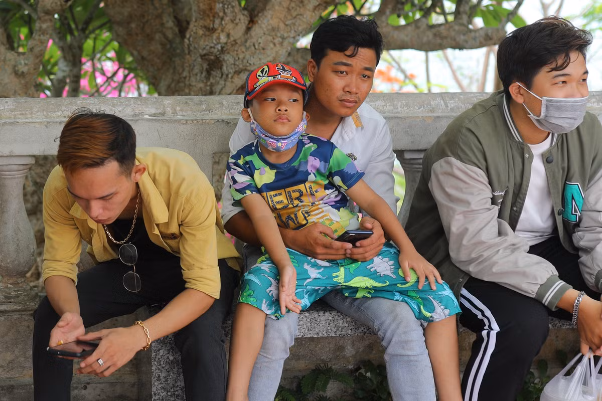 Các ghế đá xung quanh ngọn Hải Đăng luôn trong tình trạng không còn chỗ trống. Nhiều phụ huynh phải bế con tránh nắng trong các bóng râm để chờ người thân chụp ảnh xong.