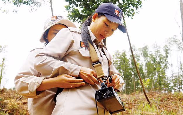 Các chị giúp nhau mang máy dò tín hiệu.