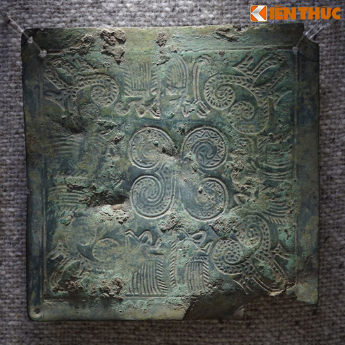 Trên một mặt tấm che ngực trang trí các hoa văn tiêu biểu của văn hóa Đông Sơn như văn vạch ngắn song song, văn vòng tròn có tâm, vòng tròn tiếp tuyến, văn chữ X và văn người hóa trang bơi thuyền, văn cá sấu…