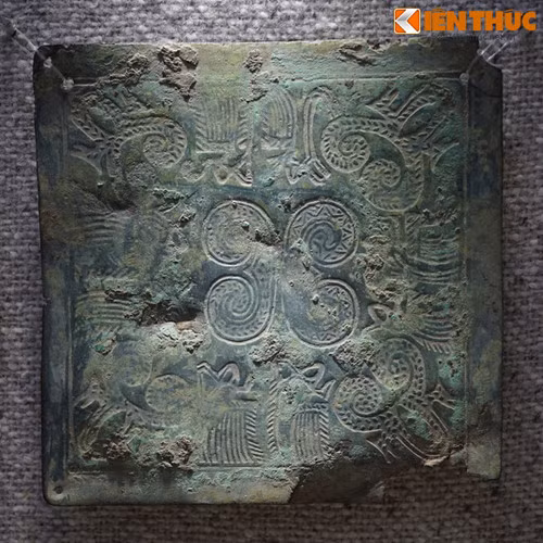 Trên một mặt tấm che ngực trang trí các hoa văn tiêu biểu của văn hóa Đông Sơn như văn vạch ngắn song song, văn vòng tròn có tâm, vòng tròn tiếp tuyến, văn chữ X và văn người hóa trang bơi thuyền, văn cá sấu…