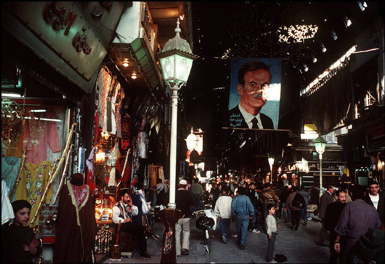 Bên trong một khu mua sắm ở thủ đô Damascus của Syria năm 1995. Tấm poster cỡ lớn in hình Tổng thống Hafez el Assad, cha đẻ của Tổng thống Syria đương nhiệm Bashar al-Assad. Ảnh: Magnum Photos.