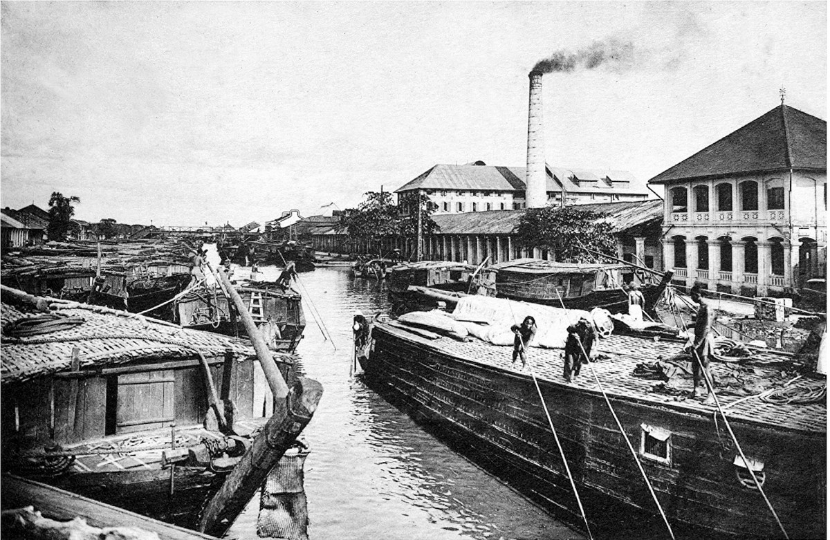 Thuyền bè qua lại trước một nhà máy xay ở vùng ven Sài Gòn - Chợ Lớn. Con kênh trong ảnh chính là kênh Tàu Hũ.