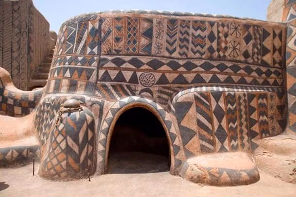 Mỗi căn nhà tại Tiebele đều có kiểu vẽ trang trí tường khác biệt, độc nhất. Việc sơn họa tiết trên nhà cửa được xem là hoạt động cộng đồng và được phụ nữ thực hiện. Nhiều nguyên liệu dễ kiếm được sử dụng làm màu sơn như màu đen lấy từ than, trong khi màu nâu lấy từ đất sét màu. Họa tiết được vẽ lên sau khi nhà đã xây xong. Ảnh: SIWLL.